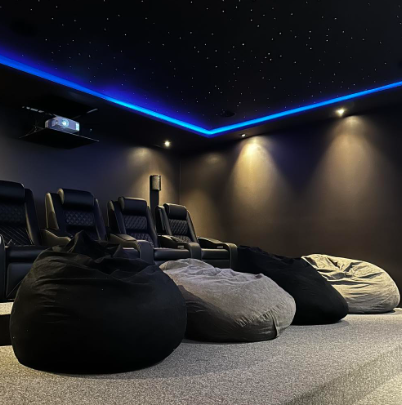 Home cinema dedicado com poltronas reclináveis e céu estrelado